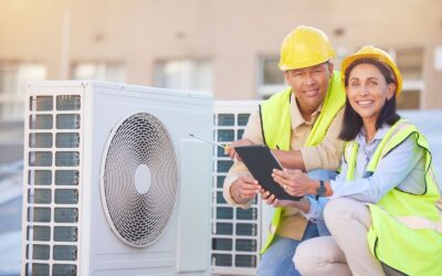 Two engineers are working on an air conditioning unit.